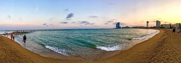 Sunset over sandy beach by the sea in Barcelona.