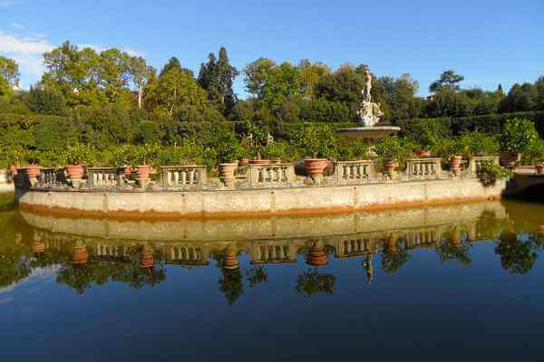 Statue and trees behind a lake in Boboli Gardens, Florence.