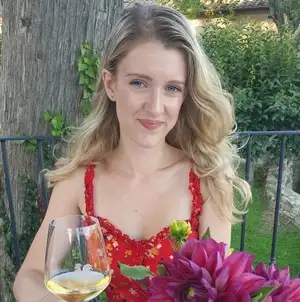 Liv with a glass of white wine and flowers in Italia.