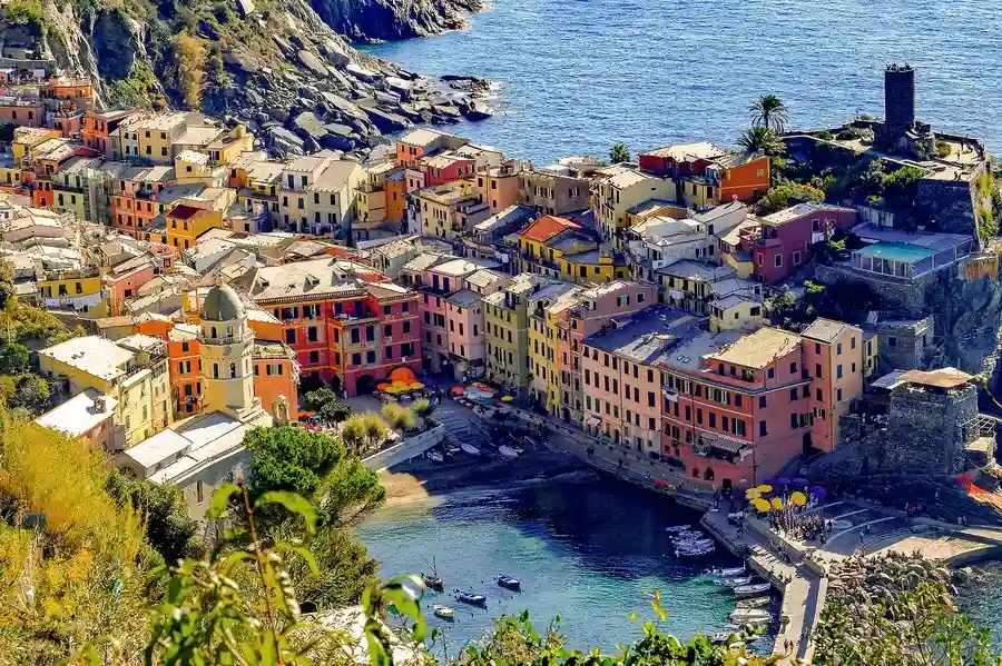 View of the colourful houses of Vernazza village, the harbour, castle and sea.