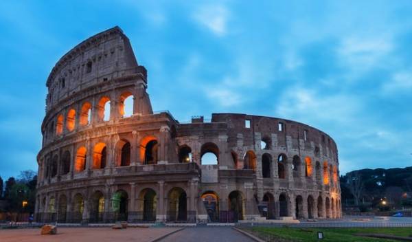 Façade of the Colosseum at sunset in Rome on a weekend trip from London.