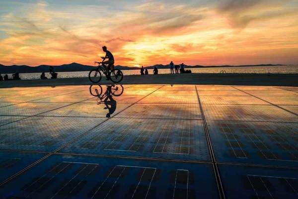 Riding a bicycle at sunset over the 'Sea Organ' seafront at Zadar.