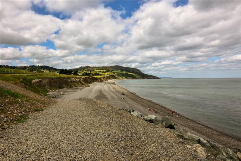 Rolling hillside backs the long length of Greystone beach beside the Irish Sea.