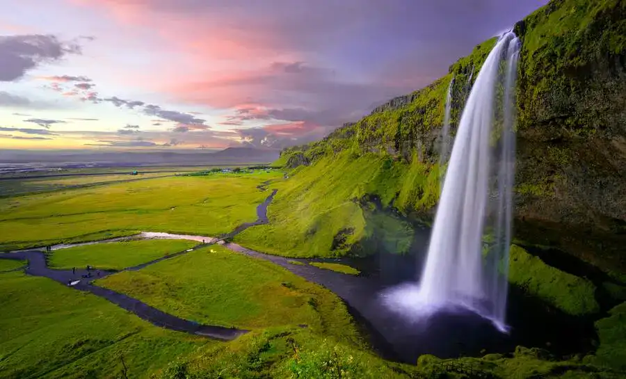 Iceland summer scene with Seljalandsfoss waterfall and green countryside.