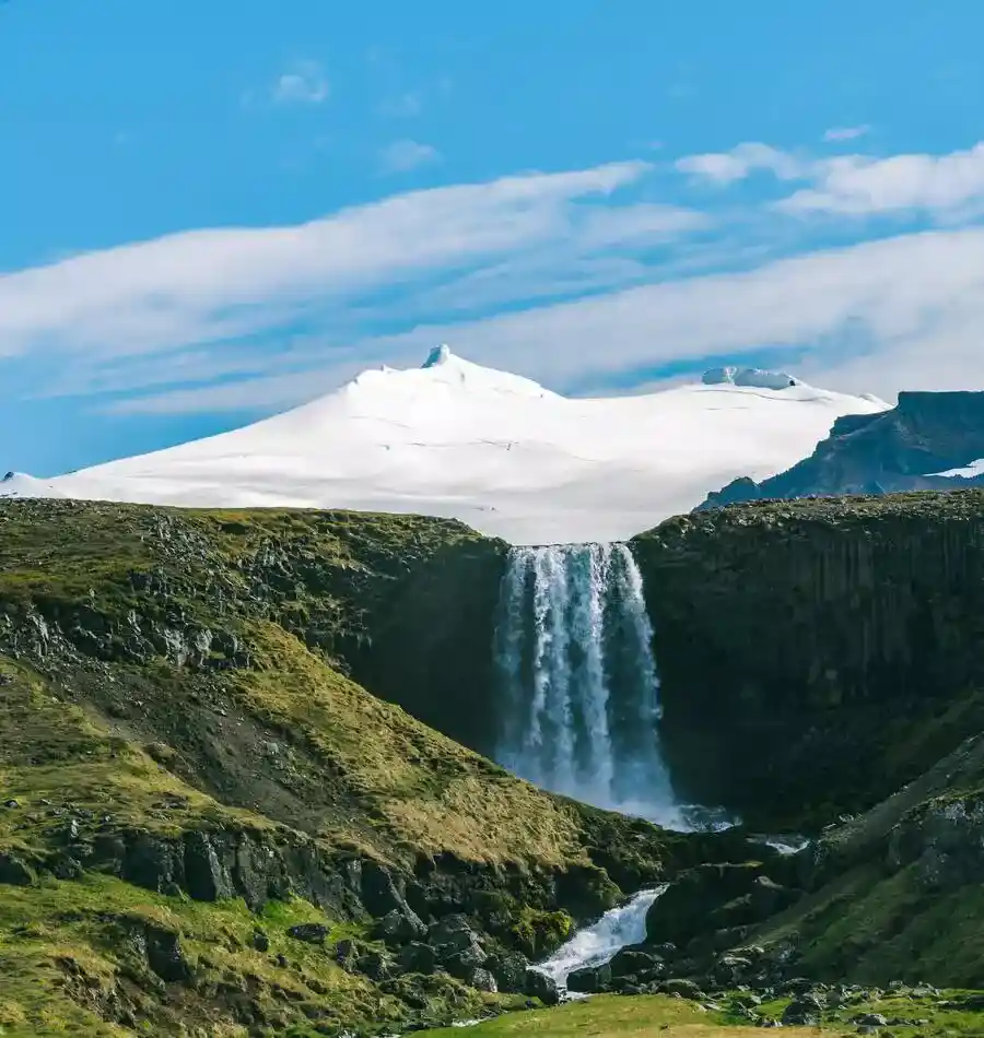 Svodufoss Falls flowing from a snowy mountain on the Snaefellsnes Peninsula.