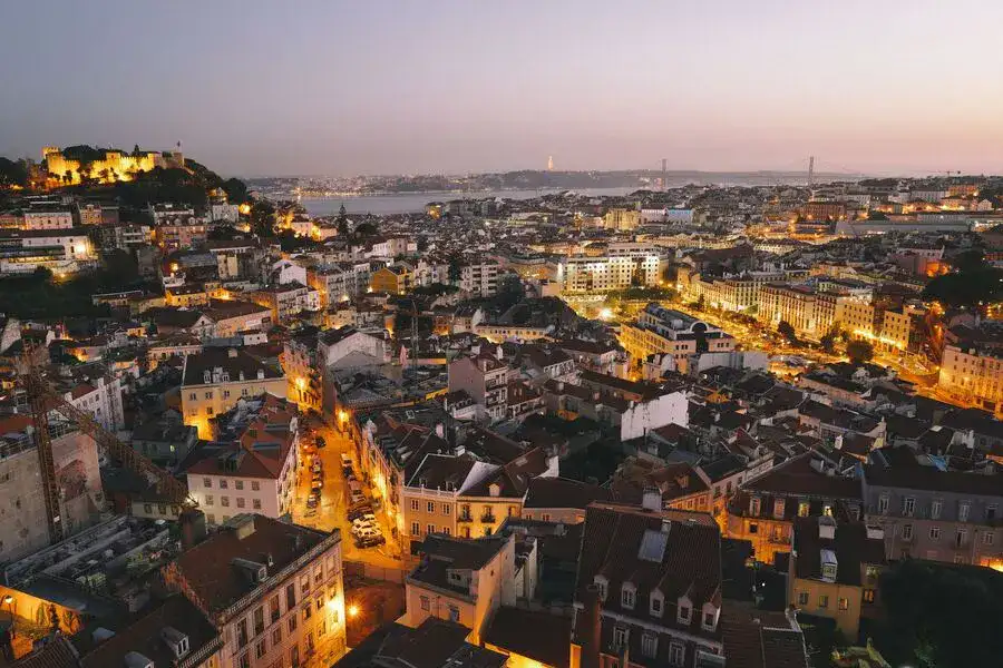 Lisbon skyline panoramic view with city lights at dusk.