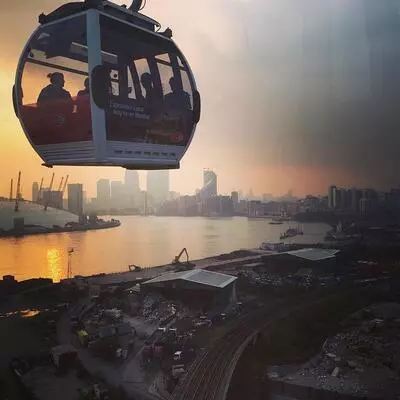 A London cable car trip with views over the docklands at sunset.