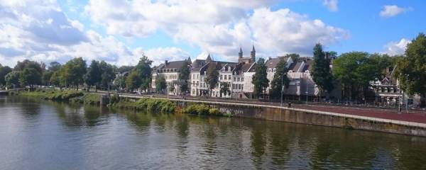 River in front of historical buildings in Maastricht.