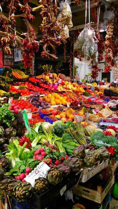 Strings of dried peppers and garlic hanging over fruit & vegetable stall in Florence Centrale Market.