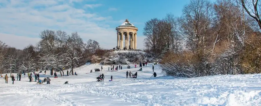 People having fun in the snow at Munich English Garden.