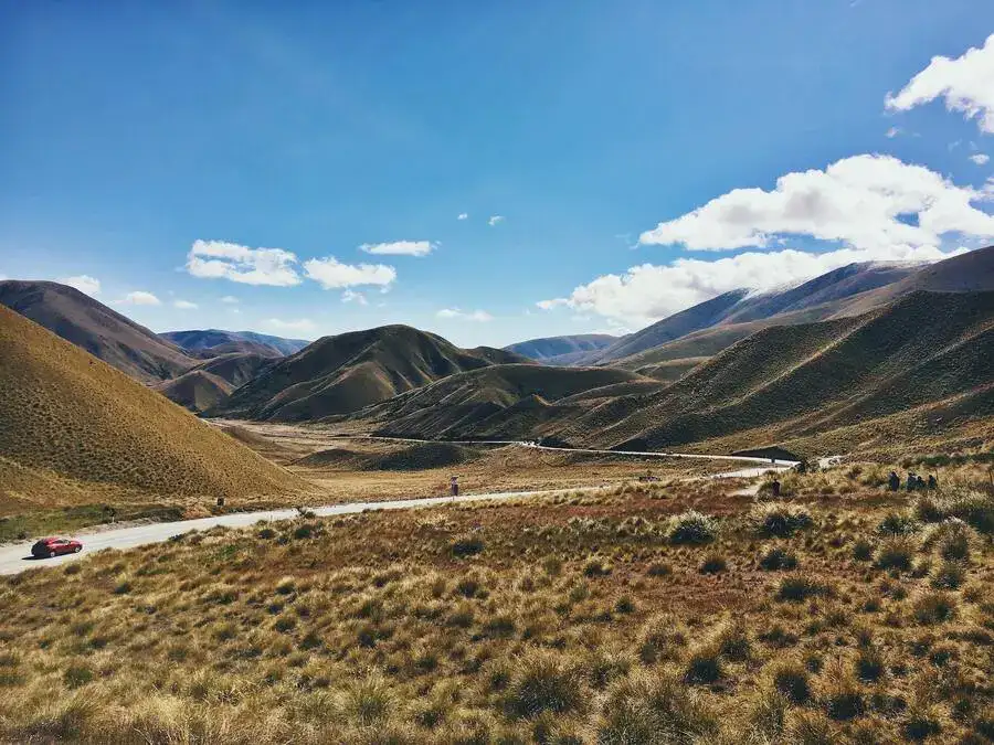 Lindis Pass road through grassland and brown hills.