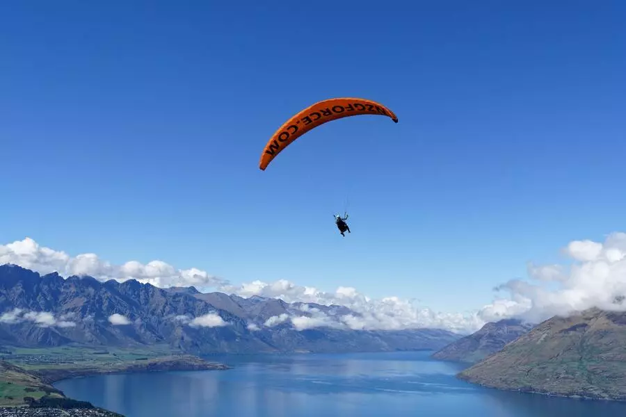 Paragliding over a lake surrounded by mountains.