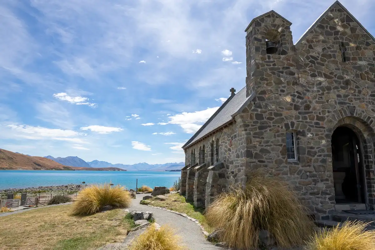 Old stone church beside a lake.