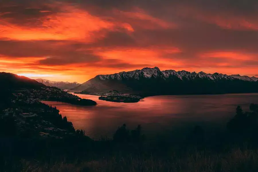 Red sunrise over Queenstown, the lake and mountains. 