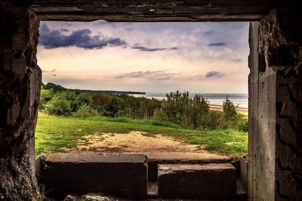 Omaha beach seen from wood frame window of war bunker in Normandy.