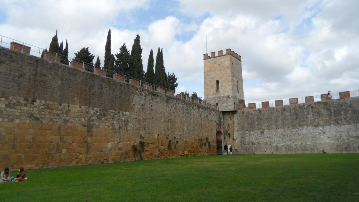 Pisa medieval stone walls with a turret.