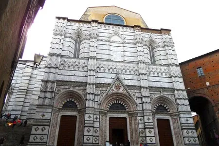 The entrance to the Baptistery is at the back of Siena Cathedral.