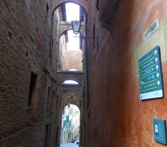 Ancient brick archways of Chiasso del Bargello passageway in medieval Siena.