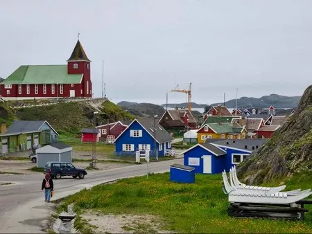 Road leading into Sisimiut with the colonial church and colourful houses. 