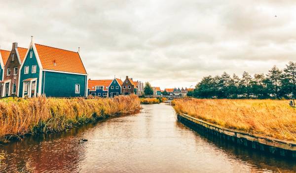 Orange and blue houses beside canal in Volendam, Holland.