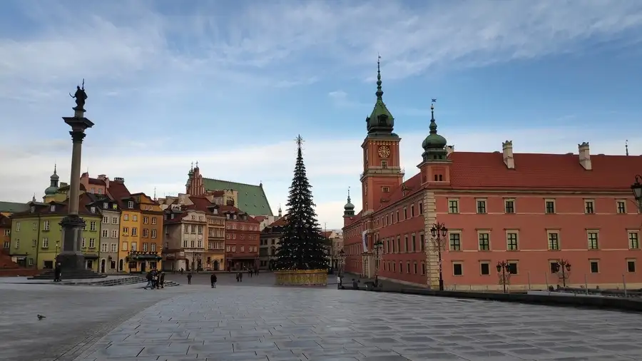 Historic buildings and huge Christmas tree in Warsaw old town in December.