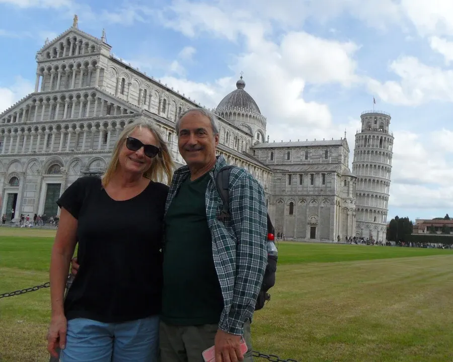 A couple standing in front of Pisa cathedral and the leaning tower.